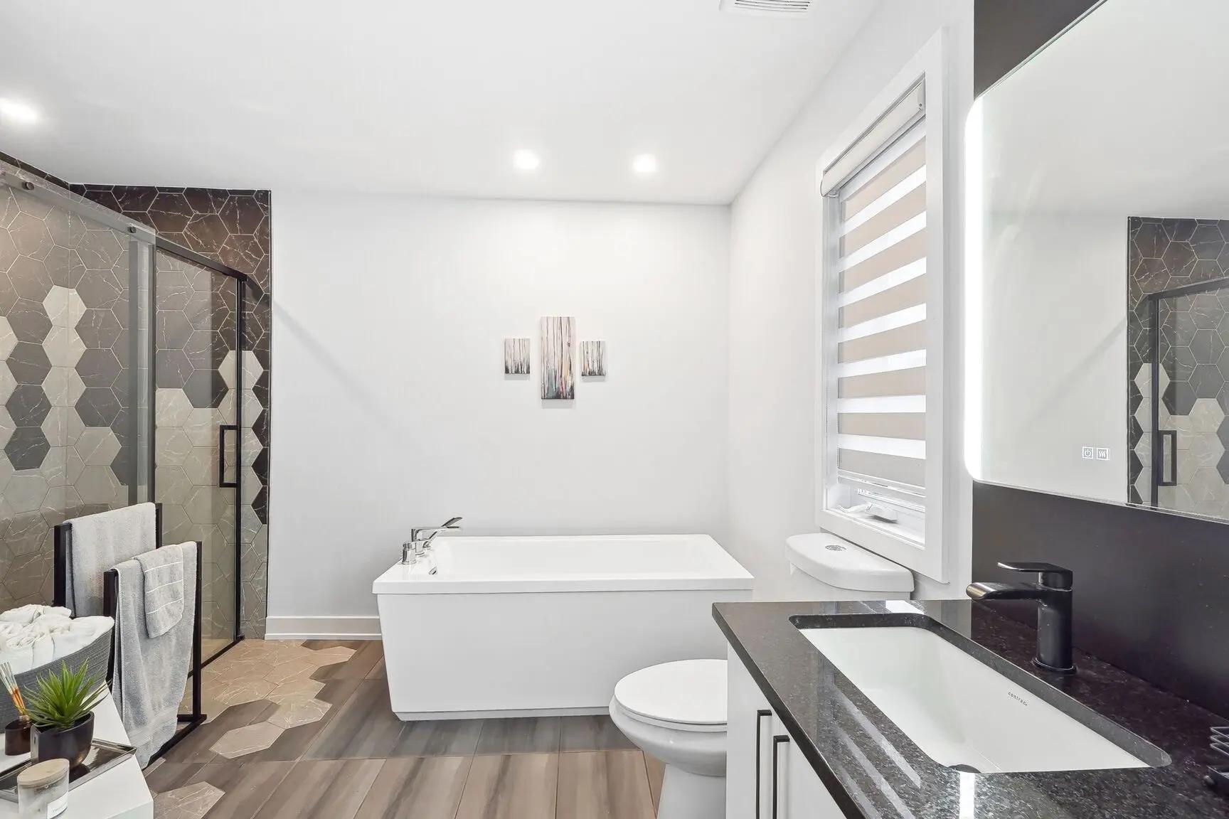 Modern bathroom with a freestanding bathtub, walk-in shower, and hexagonal tiles.