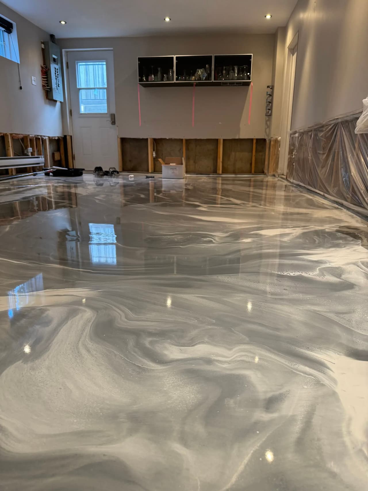 Gray and white marble effect epoxy floor in a residential room under renovation.