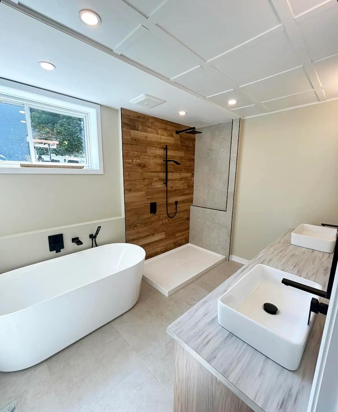 Spacious bathroom with a freestanding bathtub, a walk-in shower with natural stone cladding, and wooden elements for a warm atmosphere.