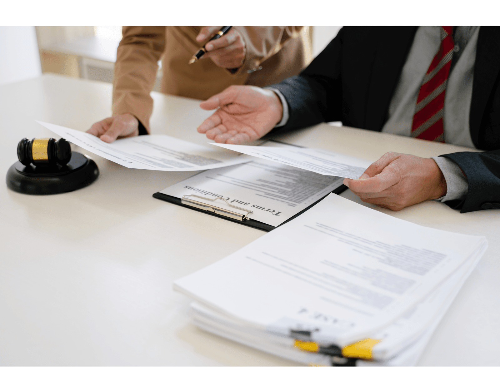 Legal meeting with contractual documents and a judge's gavel on a table.