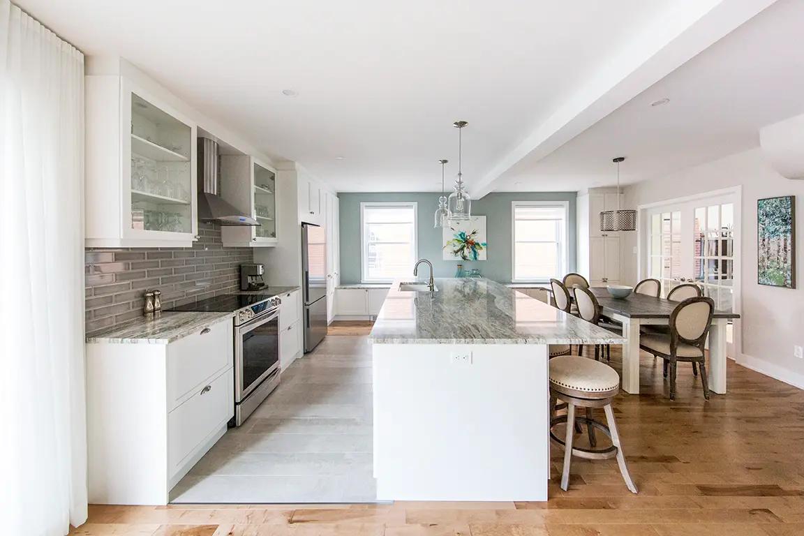 Elegant, functional kitchen combining modernity and tradition. The mix of white, grey and light wood creates a warm and welcoming atmosphere.