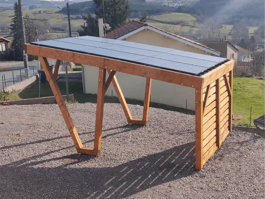 Wooden pergola with flat metal panel roof on gravel ground in a rural residential setting.