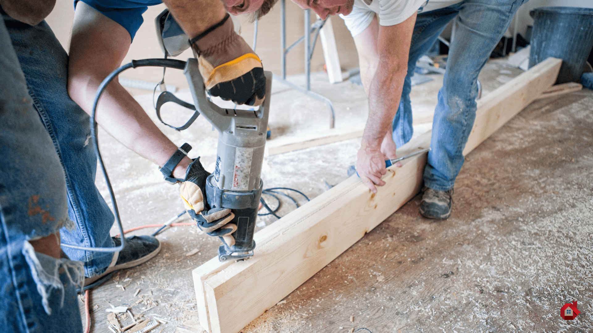 two contractors with a tool cutting a piece of wood&nbsp;