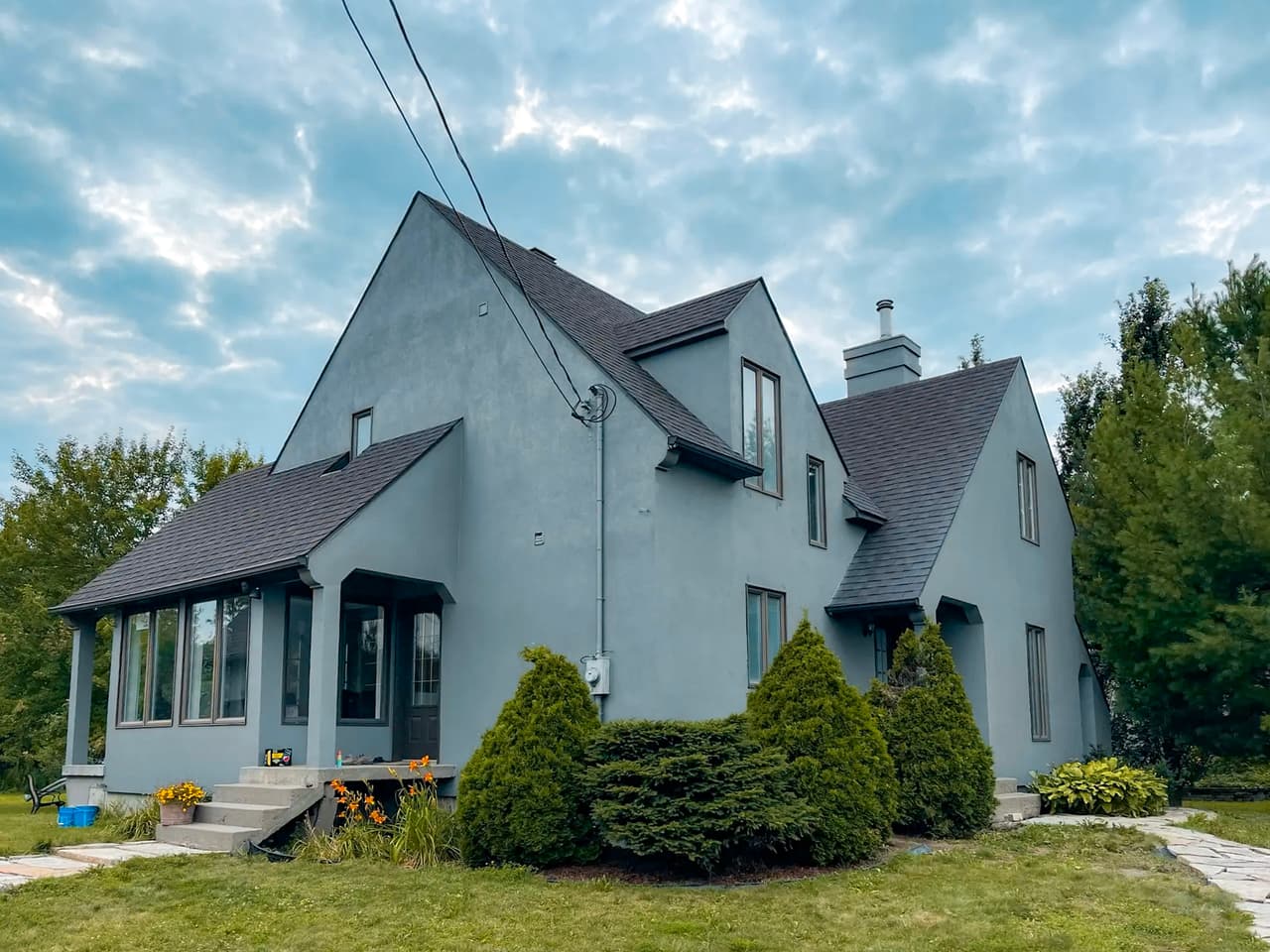 Modern blue house with smooth exterior siding, wood gable accents and balcony with wooden railing
