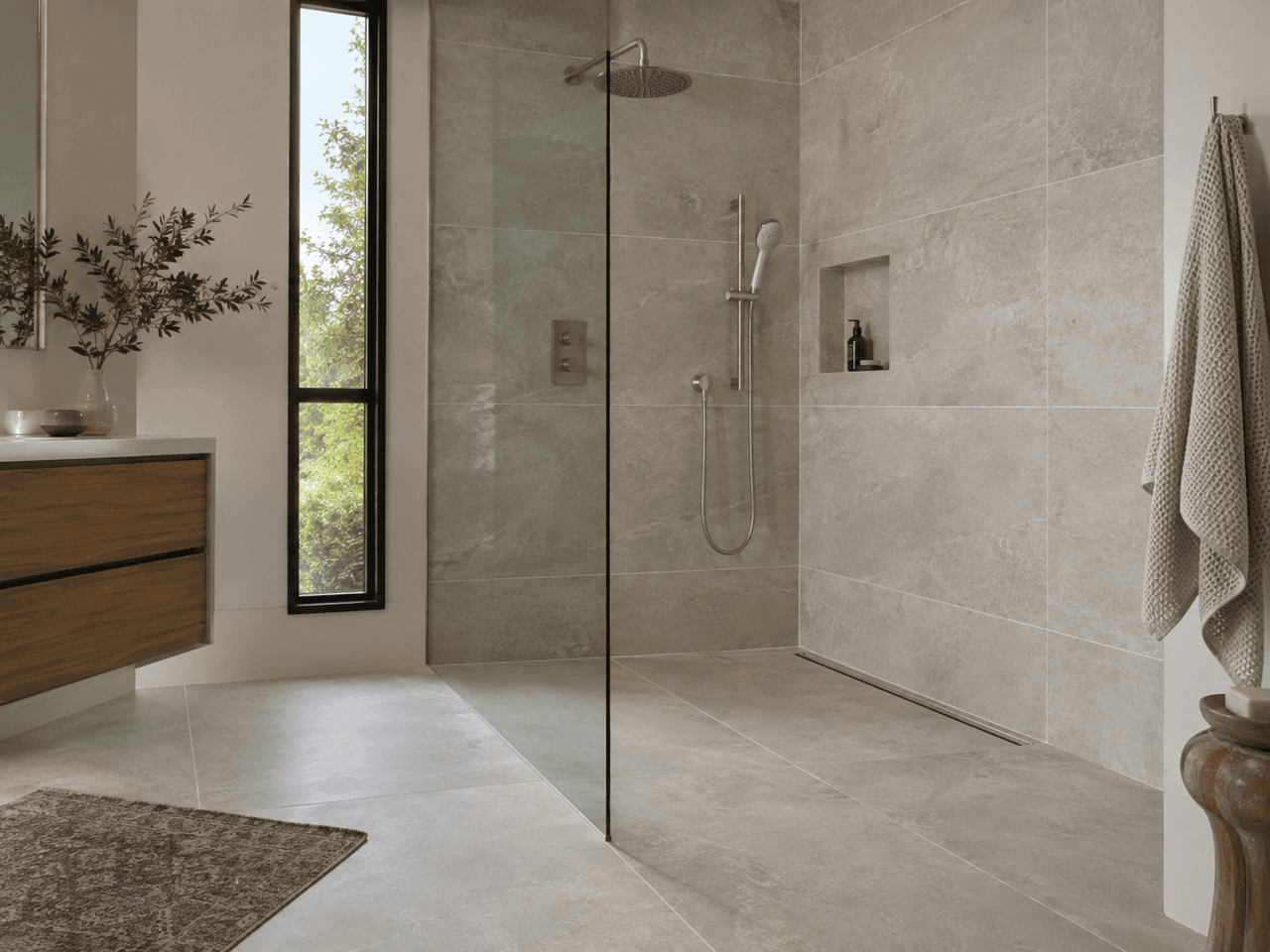 Modern bathroom with a large walk-in glass shower, large-format beige tiles, rainfall showerhead, wall niche and wood vanity