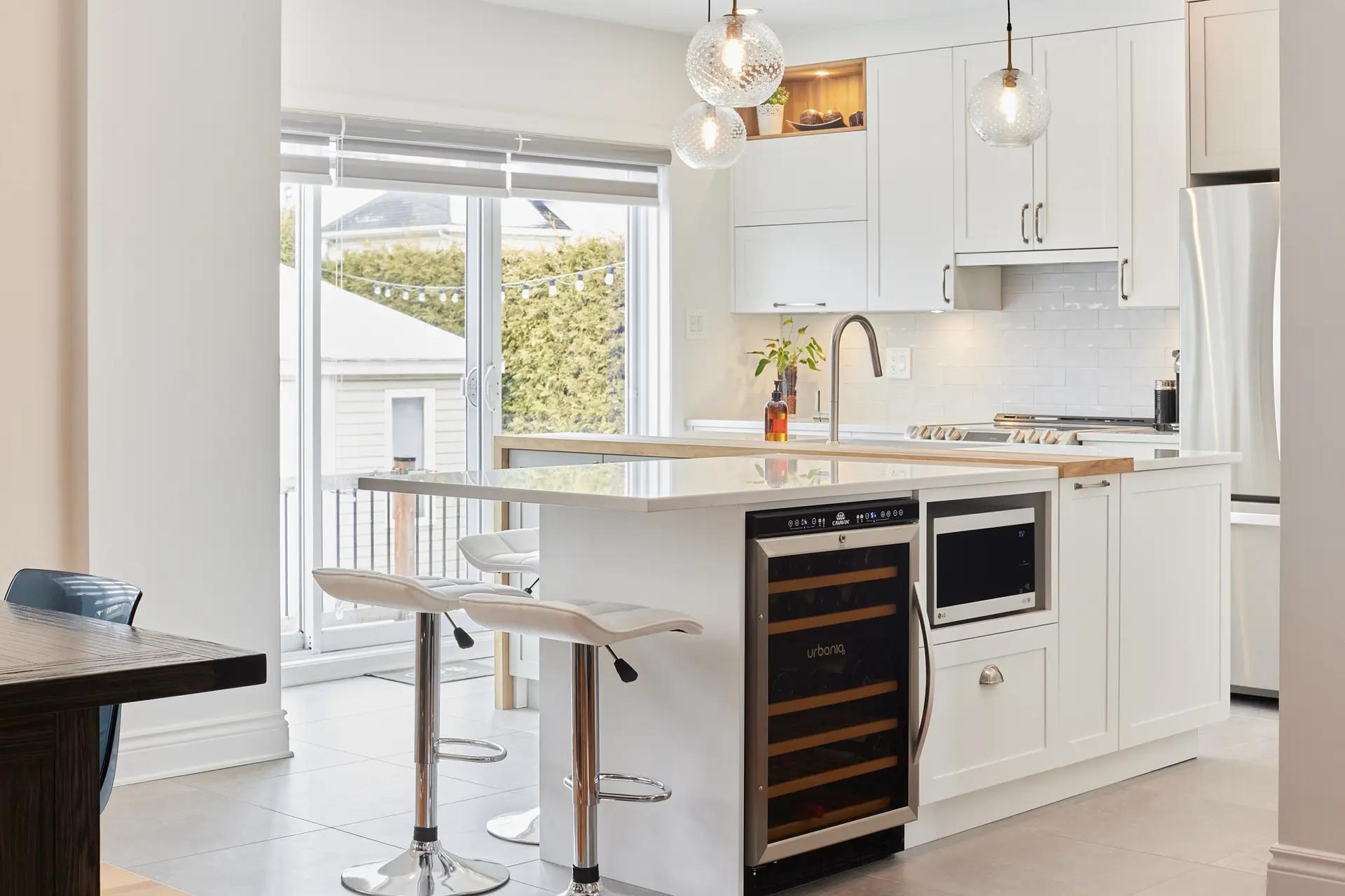 Scandinavian kitchen with a contemporary twist. The mix of white, light wood and touches of black creates a warm, uncluttered ambience. The central island is perfect for meals with family and friends.