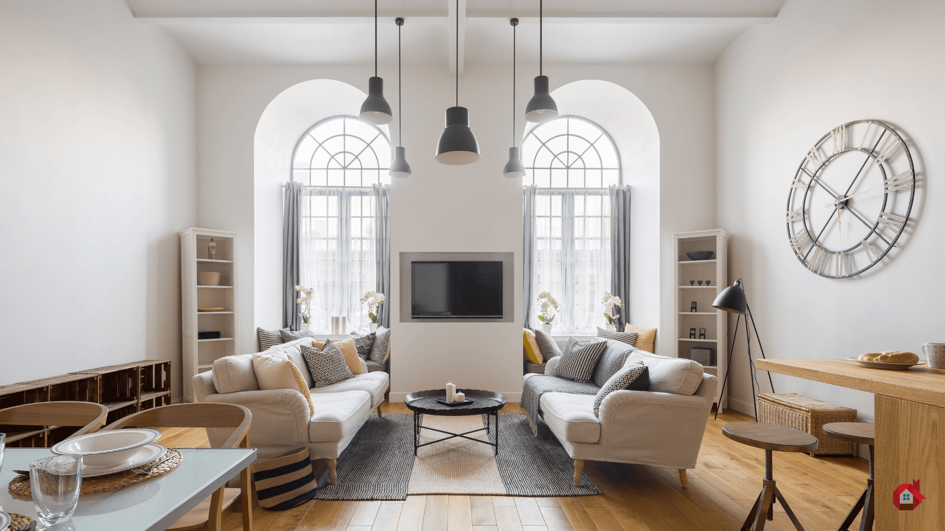 Bright, contemporary living room with high ceilings, large white sofa, wooden floor and large wall clock