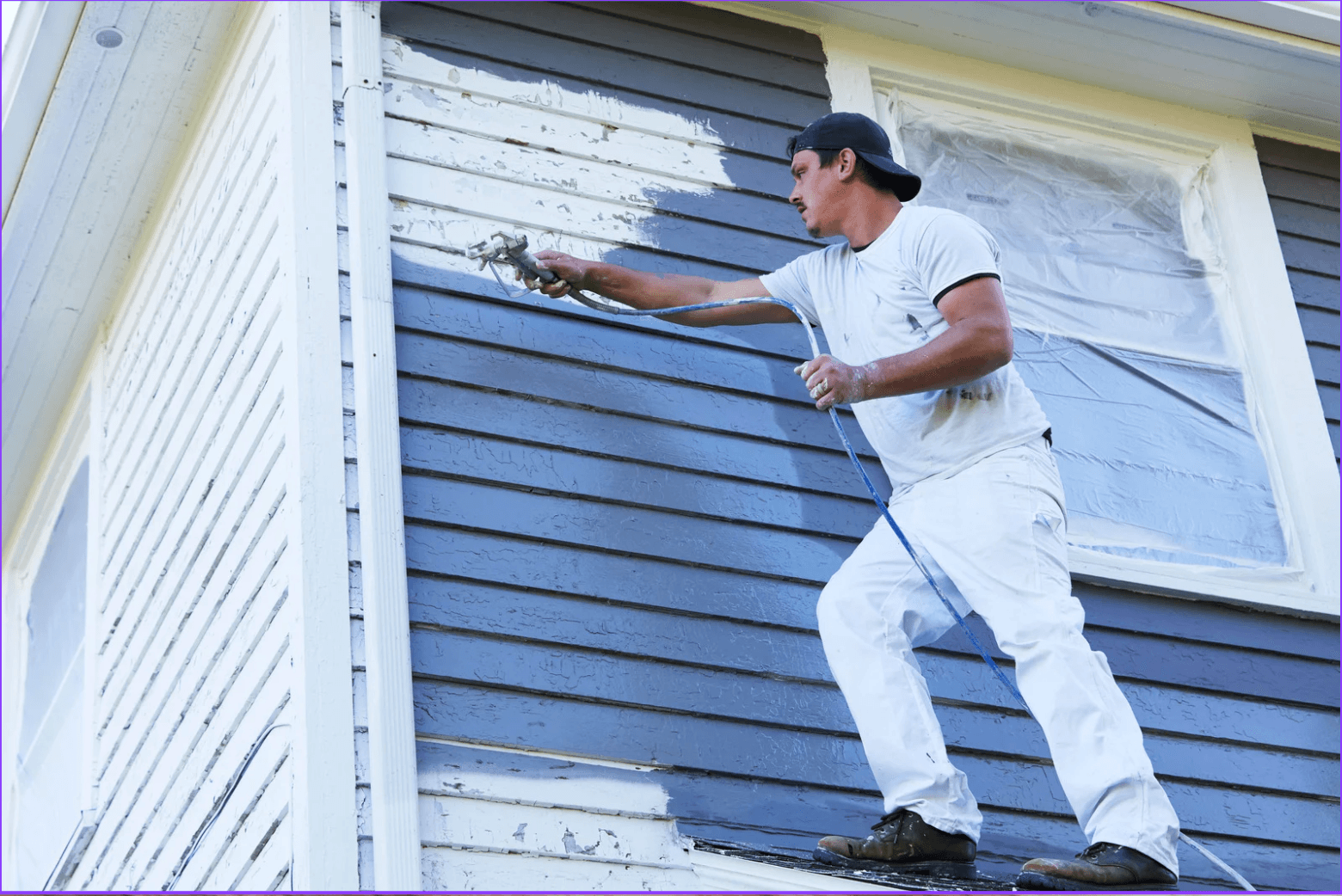 Contractor painting an exterior wall