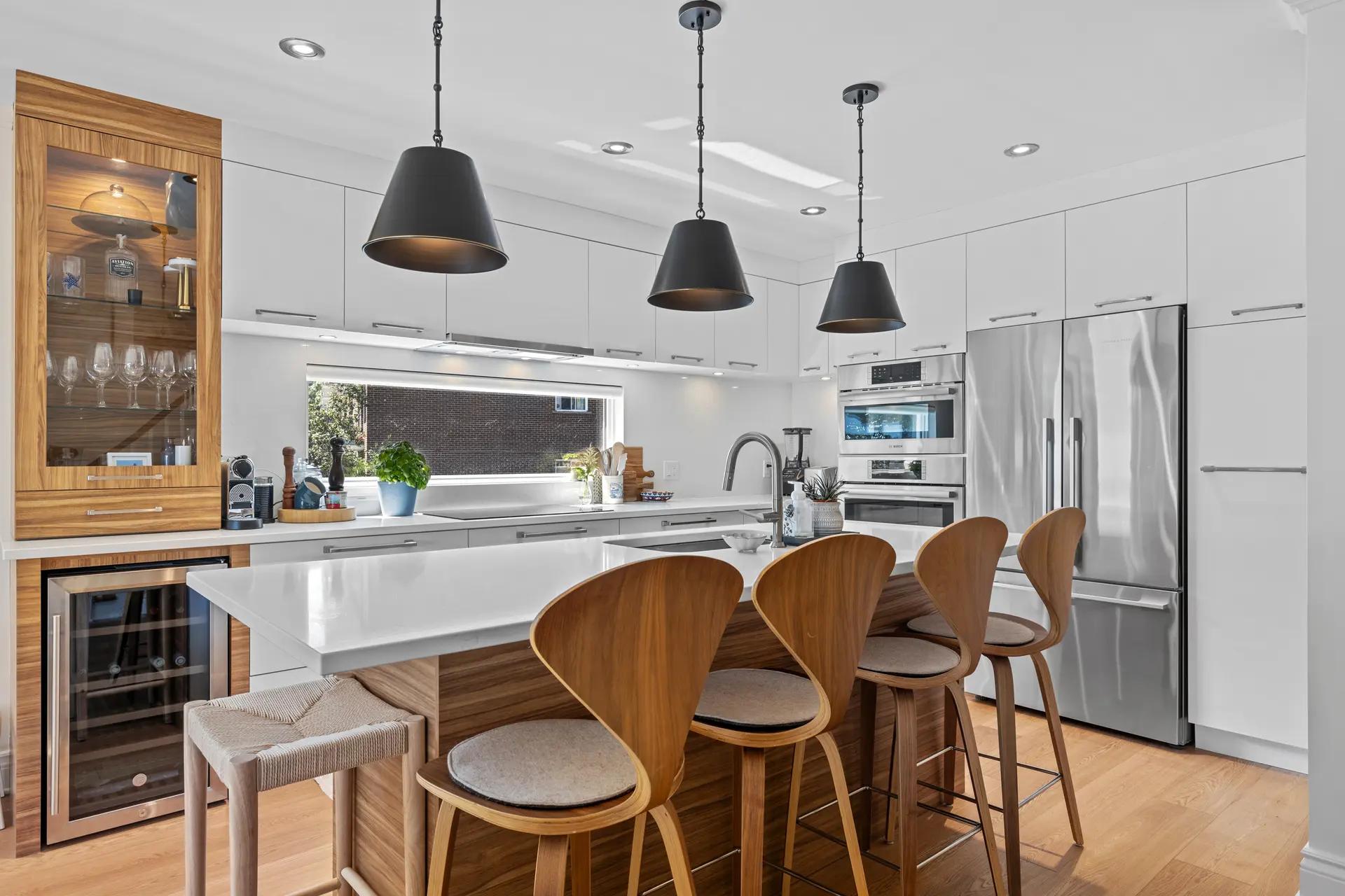 Cozy and inviting kitchen pairing wood with white. The light wooden central island makes for a good space meant for family dinners or friend gatherings