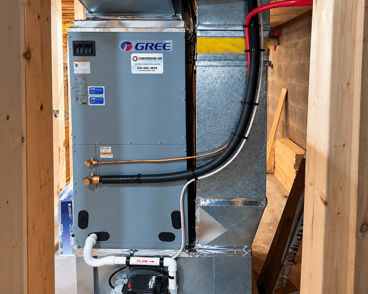 Central heating and air conditioning system installed in a basement under construction, with Gree unit, metal ductwork, insulated piping and condensate drainage.