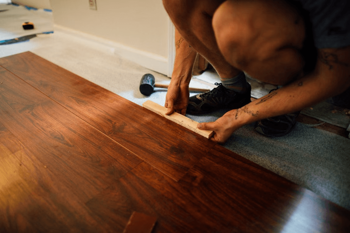 Nettoyage d’un tapis à motifs avec un aspirateur dans une pièce résidentielle lors de l’entretien intérieur de la maison.