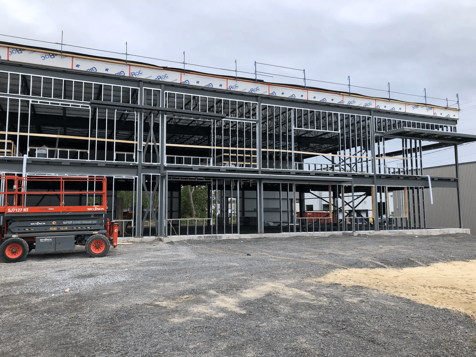 Construction of a steel-framed commercial building with scaffolding and boom lift on site