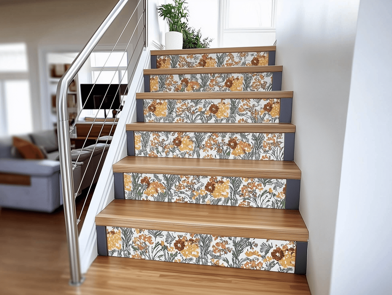 Light wood interior staircase with floral-patterned stair risers in yellow, orange and green, modern metal railing and bright white walls.