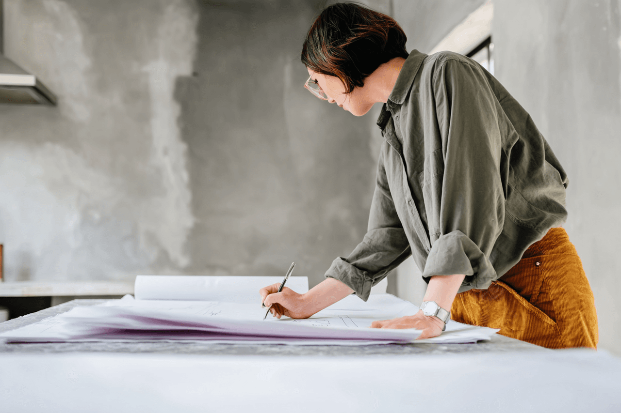 Architectural technologist drawing renovation plans in a modern interior with gray walls