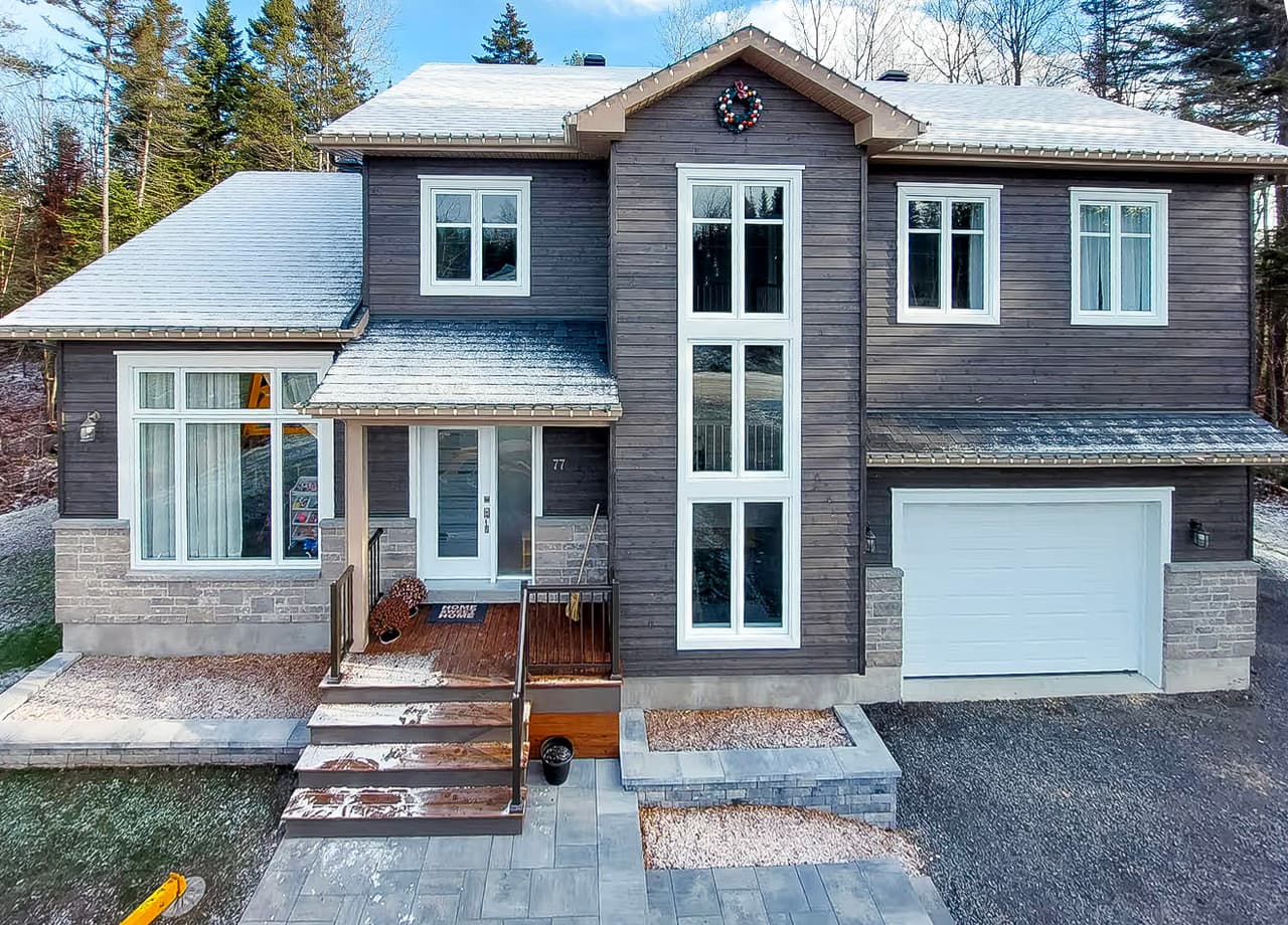 Modern single-family home with wood exterior siding, attached garage and landscaped front yard