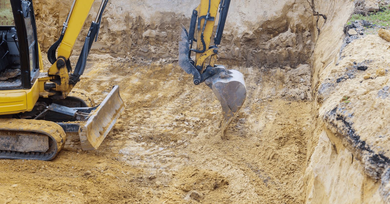 Tracked excavators performing digging and earthmoving work inside a deep excavation prepared for foundation or infrastructure construction.