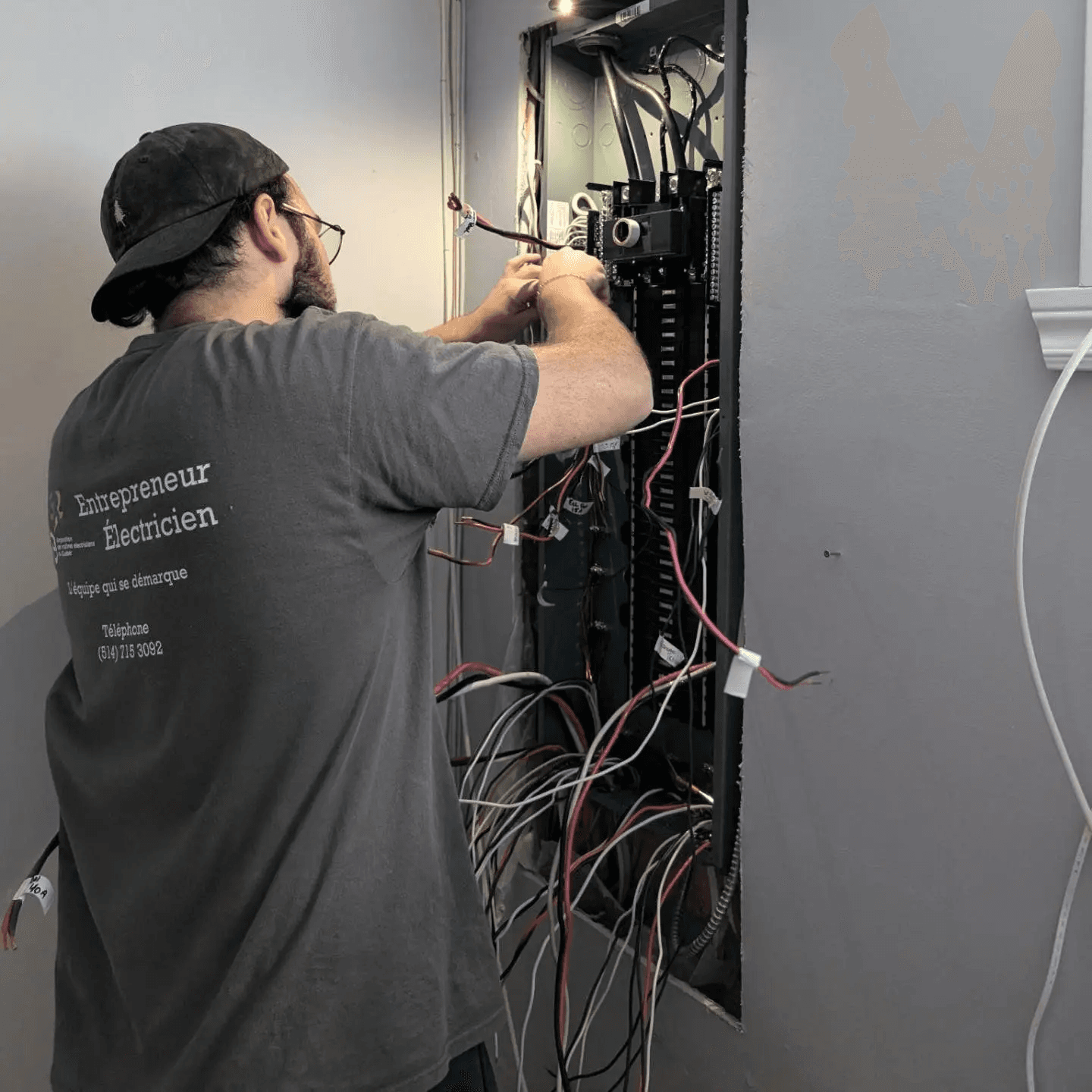 An electrician performing repairs on a residential electrical panel with exposed wiring.