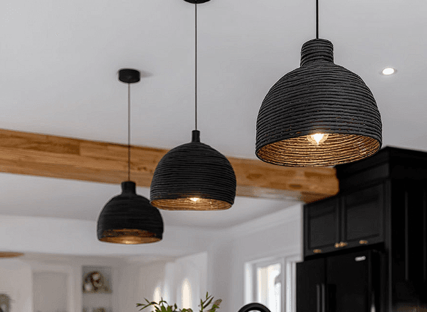 Suspended light fixtures electrically affixed to a kitchen ceiling featuring wooden beams