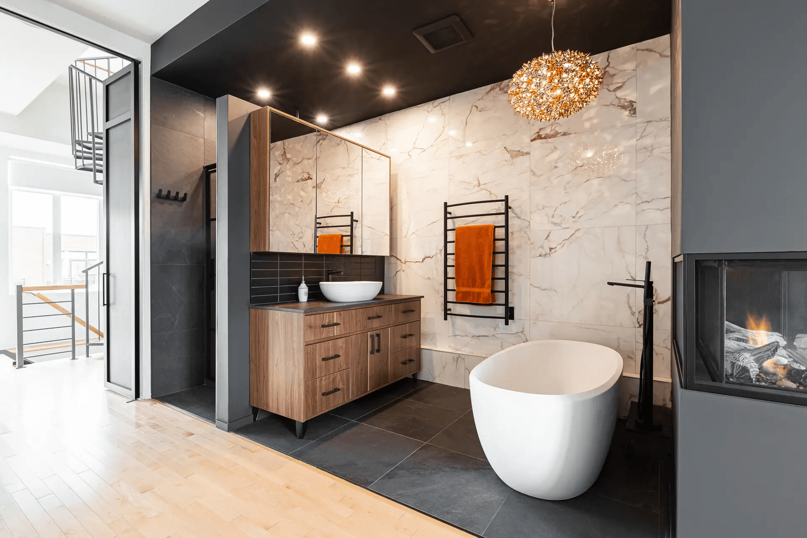 Contemporary bathroom with a freestanding bathtub, walk-in shower, wood flooring, and marble tiles.