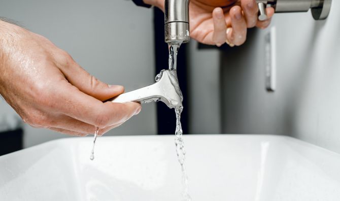 plumber repairing faucet_renoquotes.com