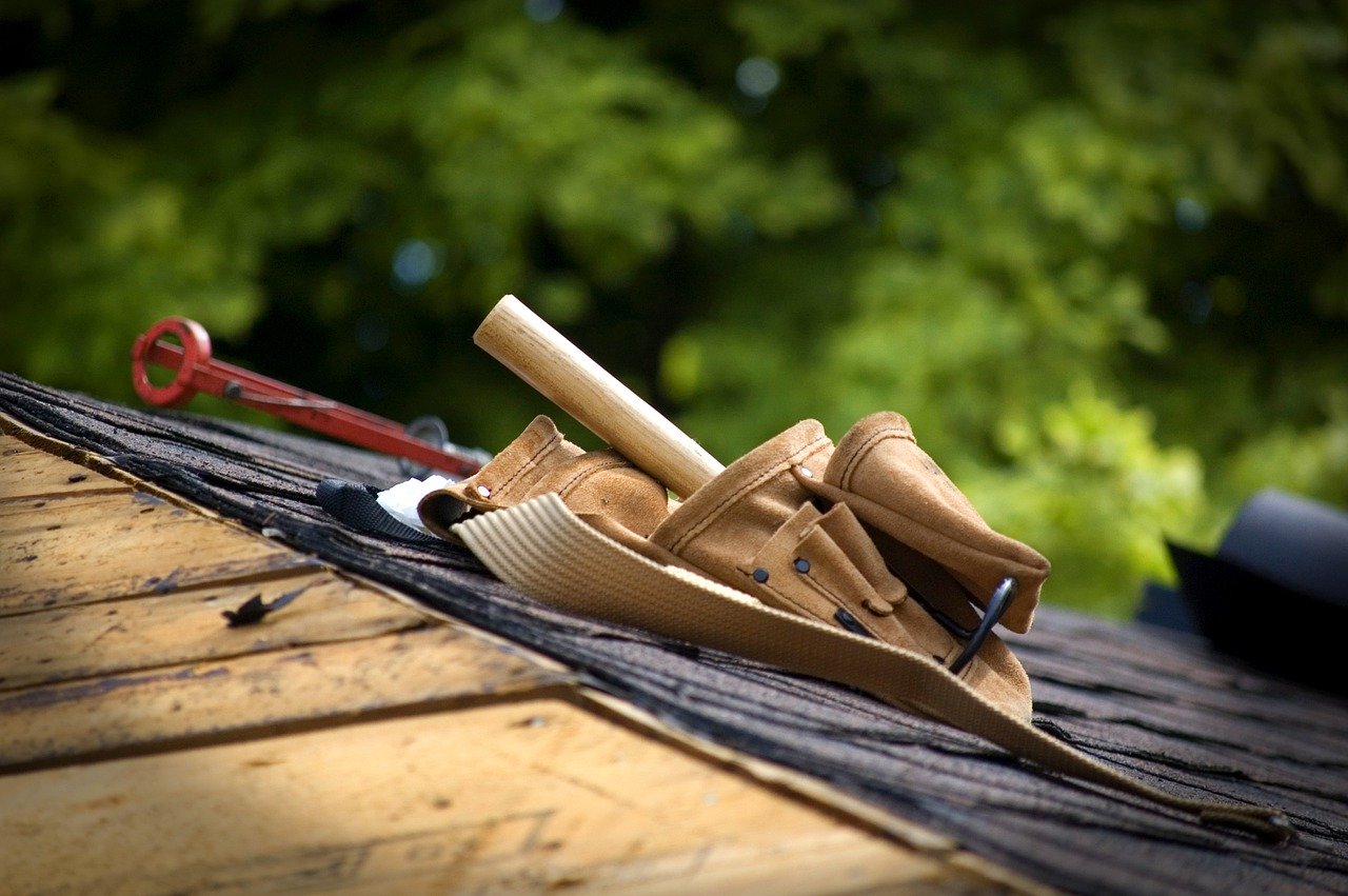 Asphalt shingle roof being fixed_Solutions for a wind-damaged roof: Replacing or Repairing